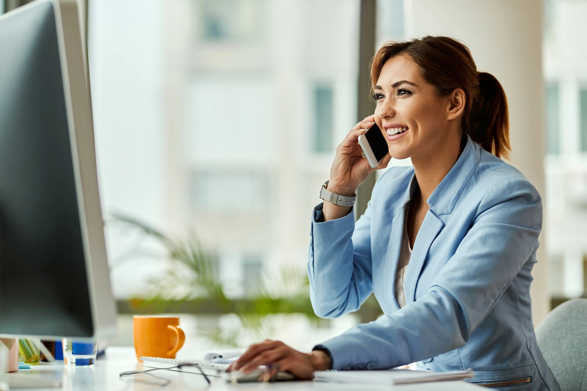 jeune-femme-affaires-heureufemme-travaillant-ordinateur-bureau-communiquant-par-telephone-portable